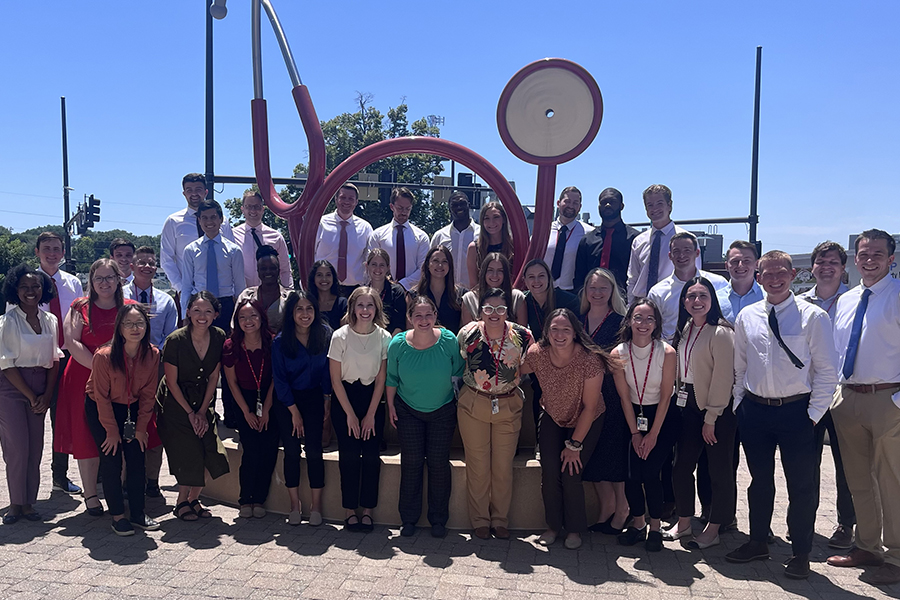 The UNMC Internal Medicine first-year residents in front of the stethoscope sculpture on the UNMC main campus