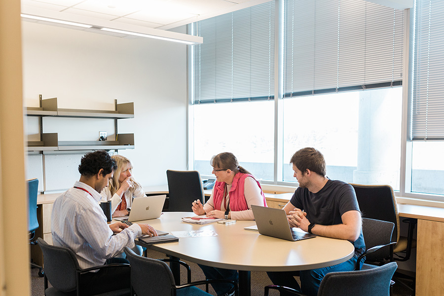 A research team at UNMC meet in a conference room.