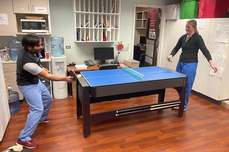 Residents and faculty compete in a ping pong tournament in the resident lounge.