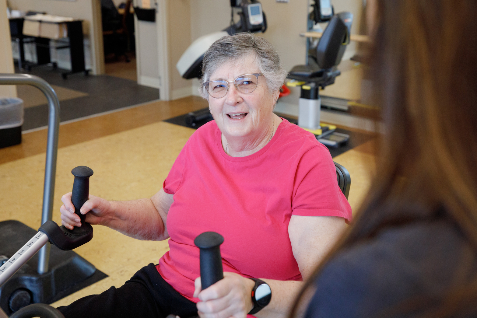 A member of Engage Wellness participating in physical activity on a recumbent bike.