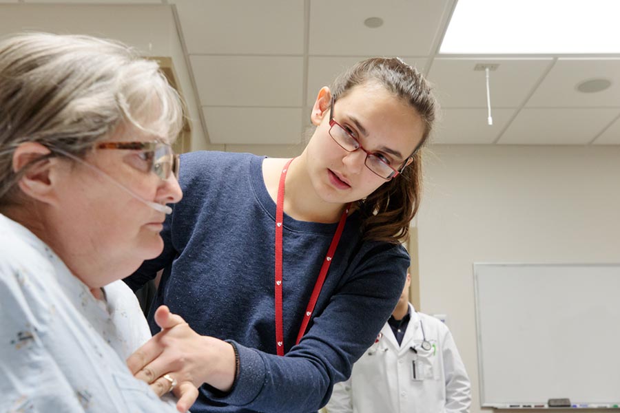 A student works with a patient