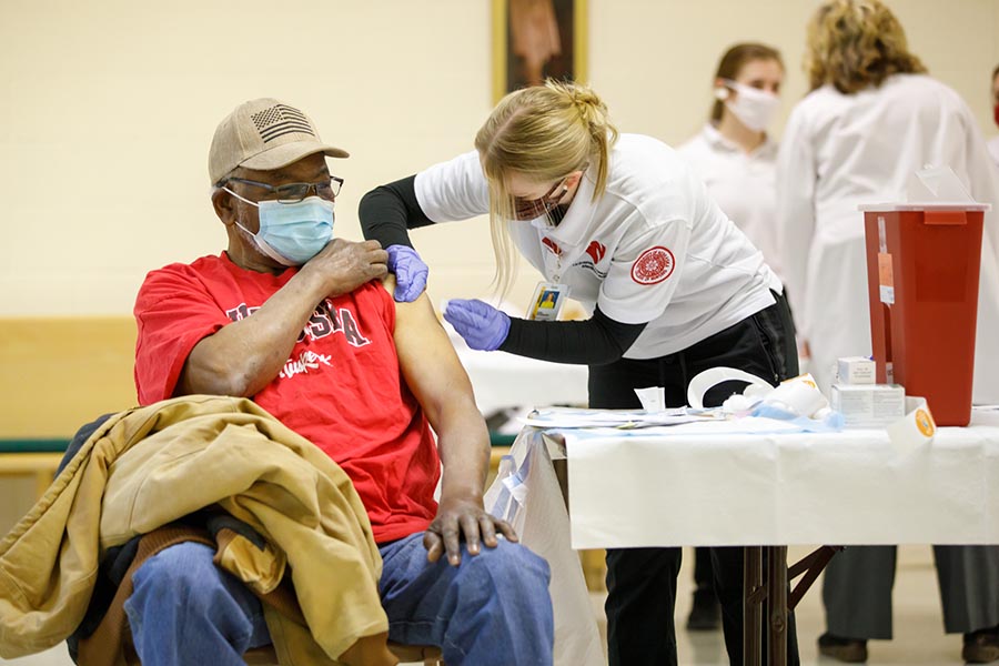 A man receives a vaccine at a community clinic