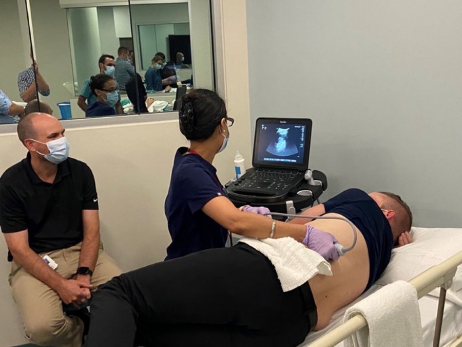 Dr. Shailly performing an ultrasound on Dr. Hettenbaugh