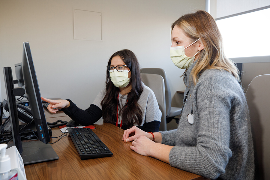 A UNMC oncology and hematology faculty member and trainee looking at a computer screen