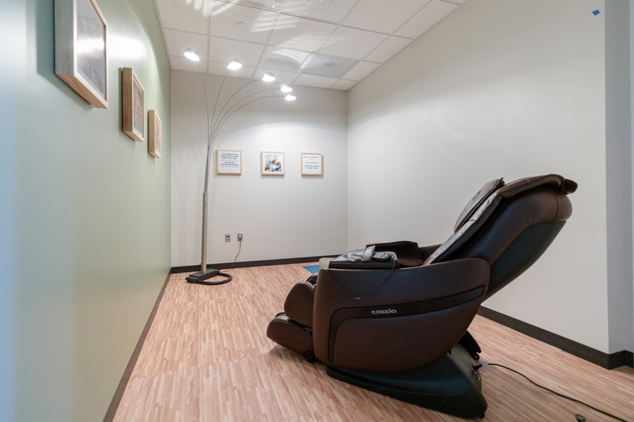 Room with massage chair and yoga mat