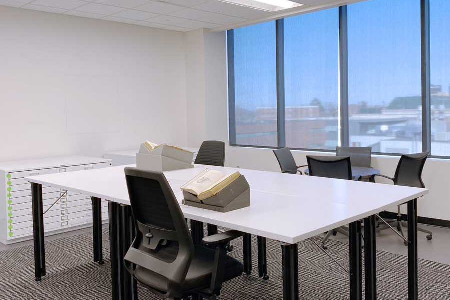 Researcher Reading Room with rare books set up on foam cradles on a large table.