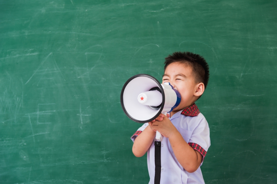 Young child talks through a megaphone.