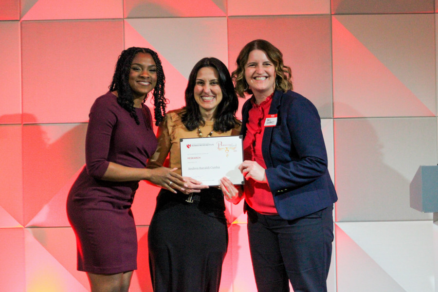 Dr. Andrea Cunha accepts Excellence in Research award.