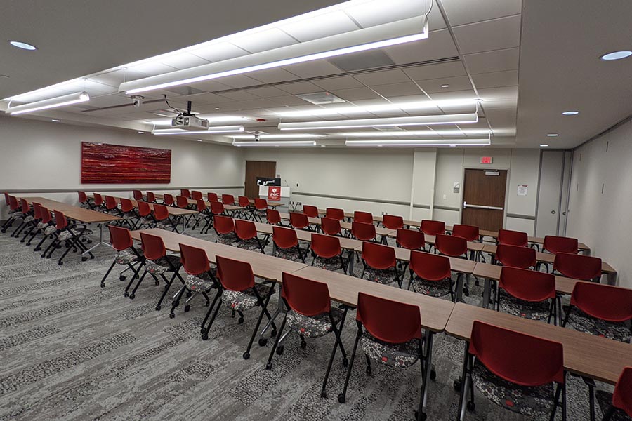 Chairs sit at tables in long lines facing a podium in MMI’s large conference room, the Warren G. Sanger Conference Center.