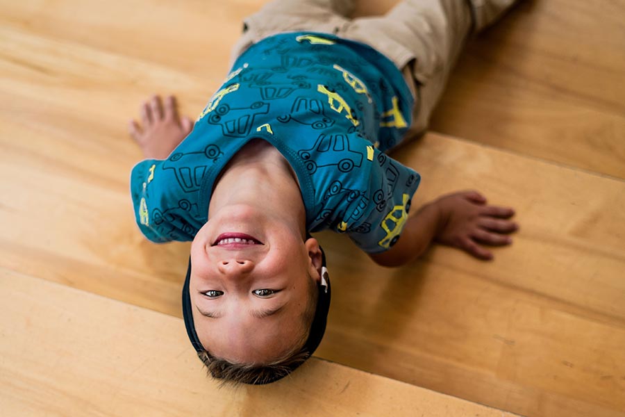 Boy laying on the floor, looking up.