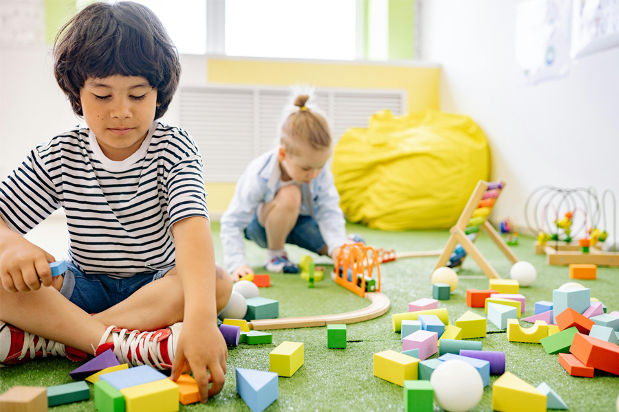 Children playing with blocks in a sunny room.