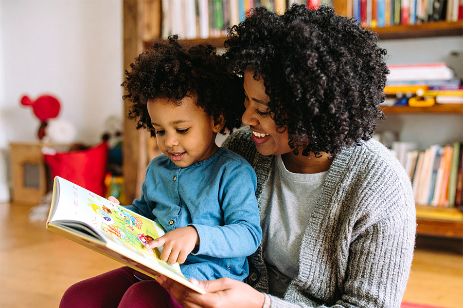 An AI-generated image of a young child reading a book with a caregiver..