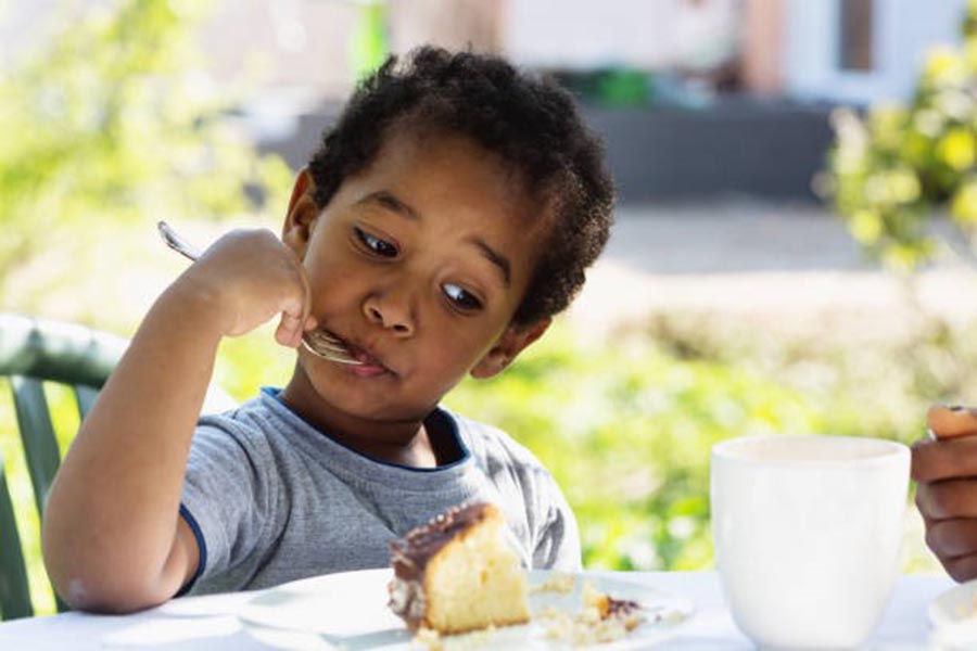 Child eating food outdoors, iStock.