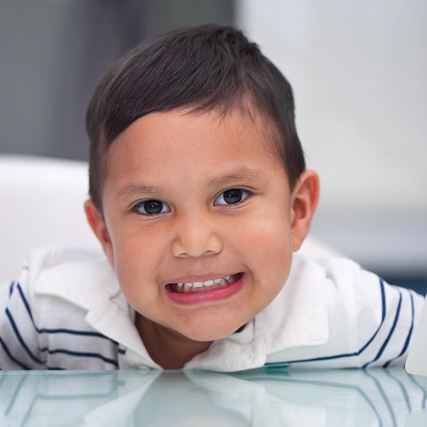 A smiling young boy sitting at a table