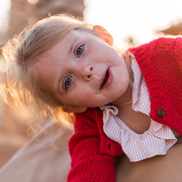 A happy young girl climbing over a playground structure