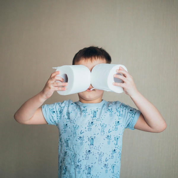 Child holds two rolls of toilet paper to his face like they're a pair of goggles.