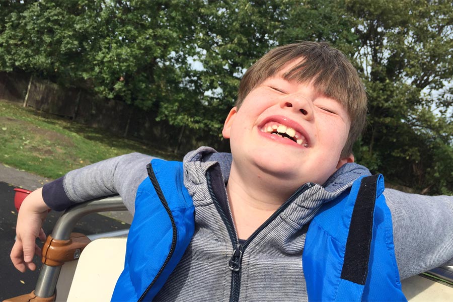 Adolescent outdoors laughing, Canva.