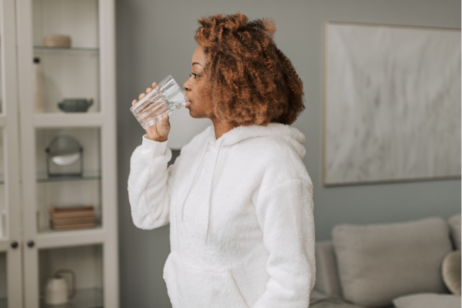 Adult drinking a glass of water.