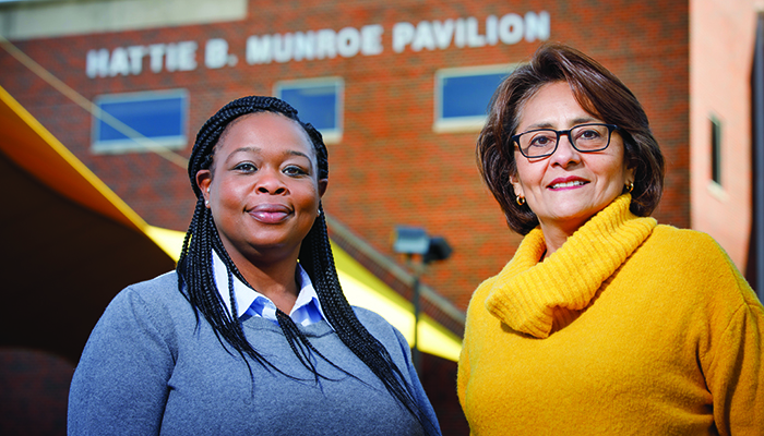 Jacqueline Hankins-Berry in a blue sweater and Graciela Sharif in a yellow sweater outside of the Munroe-Meyer Institute on UNMC's main campus