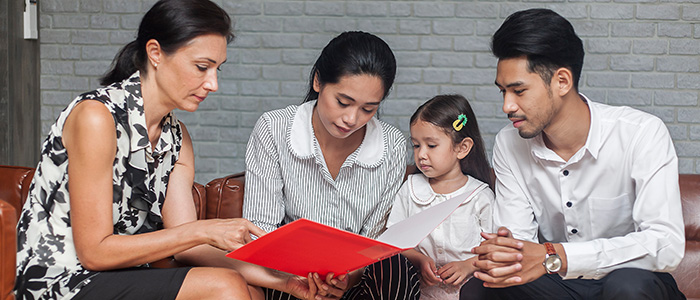 Female behavioral health provider consulting over a handout with a family; credit: Shutterstock