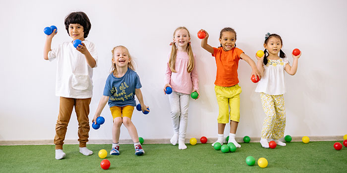 Children of all ethnicities playing with colorful balls; credit Yan Krukov from Pexels.