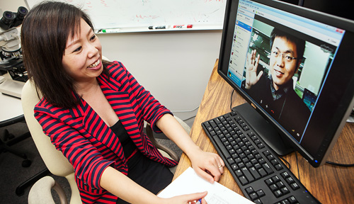 Graduate students Weiwei Zhang and Qiang Gong collaborate from half a world away on cancer research.