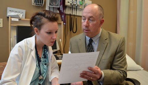 William Lyons, M.D., right, works with medical student Heather Berney.