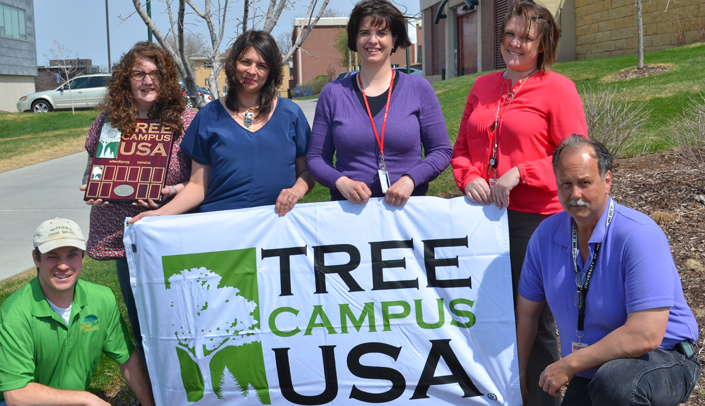 From left, Tree Campus USA committee members Graham Herbst, Kristin Watkins, Julie Sommer, Melanie Stewart, Shannon Boerner, M.D., and Tom Payne display the Tree Campus USA flag that will fly in the Durham Outpatient Center circle.