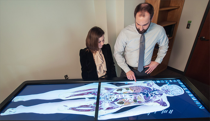 On a life-size virtual dissection table, Carrie Elzie, Ph.D., and Ryan Splittgerber, Ph.D., view 3-D images that can be incorporated into their e-learning modules. Drs. Elzie and Splittgerber are creating e-learning modules, thanks to support from the vice chancellor for academic affairs and the School of Allied Health Professions.