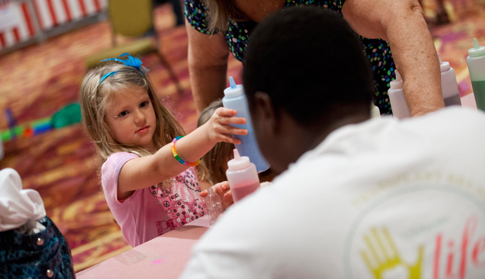A volunteer assists with children's activities at a past Solid Organ Transplant Reunion.