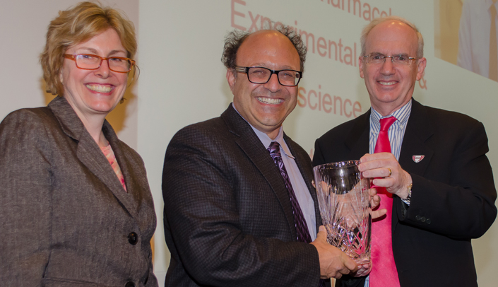 Vice Chancellor for Research Jennifer Larsen, M.D., left, and UNMC Chancellor Jeffrey P. Gold, right, congratulate Howard Fox, M.D., Ph.D., last year's Scientist Laureate. Nominations for this year's research awards are now open.
