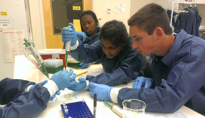 Danile Coyle, at right, works in a lab with other High School Alliance students.