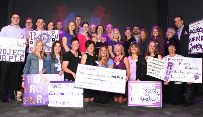 The Project Purple team in 2014 displaying a check to UNMC.