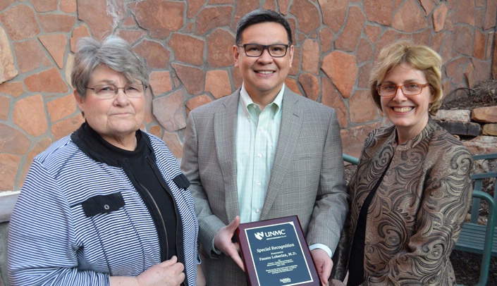 Program director Lani Zimmerman, Ph.D., left, and Vice Chancellor for Research Jennifer Larsen, M.D., right, present Fausto Loberiza, M.D., an award of recognition for his work with the Clinical Translation Research-Mentored Scholars Program.