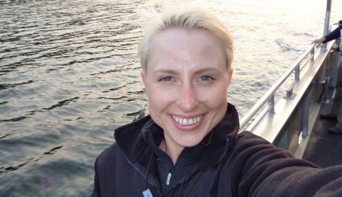 Melanie Wells watches for killer whales on a boat off San Juan Island, Wash.