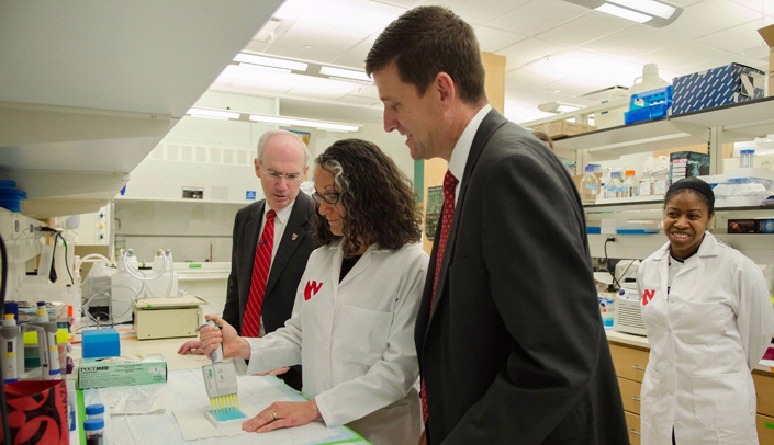 UNMC Chancellor Jeffrey P. Gold, M.D., left, and Unversity of Nebraska President Hank Bounds, Ph.D., right, visit the lab of Karen Gould, Ph.D., vice chair of graduate education and associate professor of genetics, cell biology & anatomy.