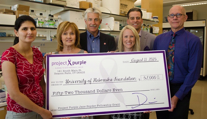 On Aug. 11, a group from Project Purple and the Lincoln Marathon came to the Omaha campus for a check presentation for $52,000 to Tony Hollingsworth, Ph.D. (far right). Project Purple was the sole benefactor of funds from the Lincoln Marathon. Project Purple funds pancreatic cancer research, and with funds raised at the Lincoln Marathon, the organization will be funding a fellow in Dr. Hollingsworth’s lab. From left to right,  Kamiya Mehla, Ph.D., Nancy Sutton Moss, Glen Moss, Elli Zadina, Dino Verelli and Dr. Hollingsworth.