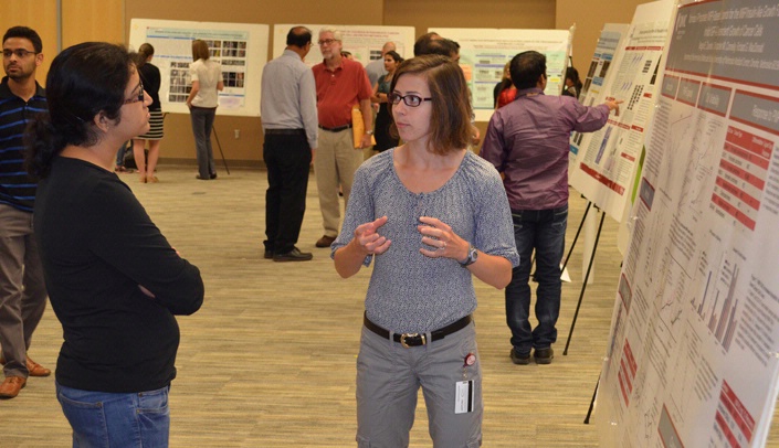 Megan Zavorka, Ph.D. candidate, discusses her poster presentation at the UNMC Department of Biochemistry and Molecular Biology's annual symposium last week.