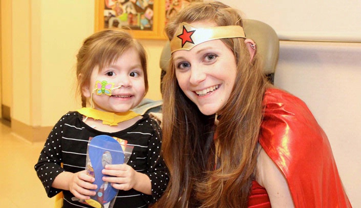 Transplant patient Eden Schmitz could not wait to meet Wonder Woman, a.k.a. graduate student Heather Talbott. (Photo by Jenny Nowatzke, Nebraska Medicine)