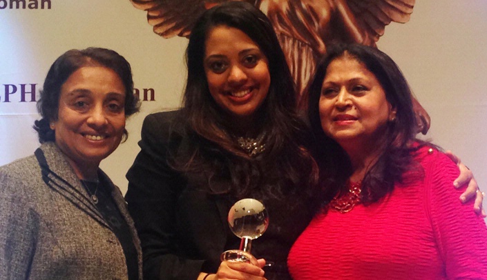 Krupa Savalia, Ph.D., center, receives her award from Rita Singh, CEO and founder of Elite Women Around the World®, as her mother, Ranjan Savalia, left, looks on.