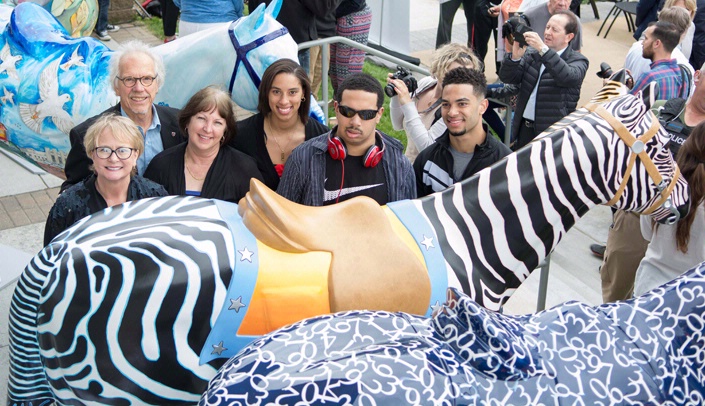From left, UNMC's Deb Thomas and Keith Swarts stand with Deb Kielty-Tynes, Jordan Tynes, Elijah Tynes, and Avram Tynes, the family of fallen Omaha police officer Kirk Tynes, at the unveiling of the Horses of Honor. The Fred & Pamela Buffett Cancer Center sponsored the horse honoring Officer Tynes.