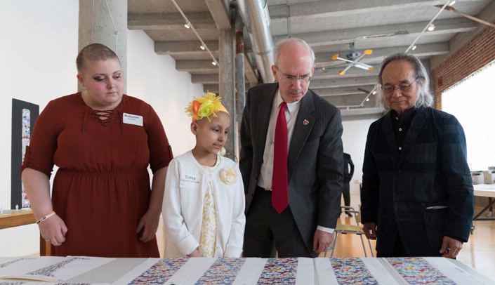 Looking at the designs for the Search Tower are (left-right) two cancer patients being treated at Nebraska Medicine -- Autumn Sullivan, 16, and Daisy Anguiano Miranda, 9 -- UNMC Chancellor Jeffrey P. Gold, M.D., and Artist Jun Kaneko.