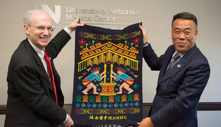 UNMC Chancellor Jeffrey P. Gold, M.D., left, and Chuanzhu Lv, M.D., president of Hainan Medical University, display a gift Dr. Lv gave Dr. Gold at the signing ceremony.
