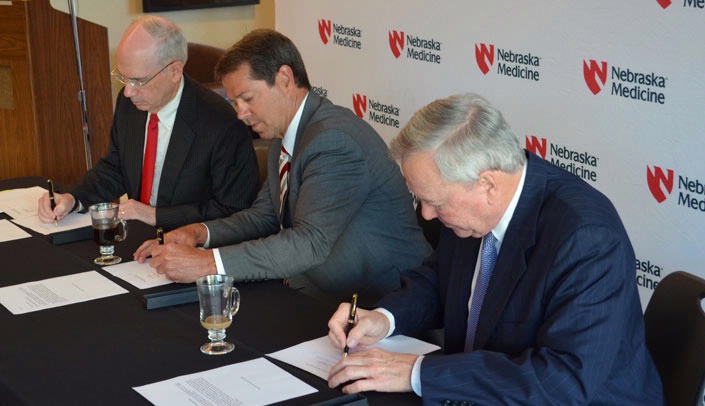 From left, UNMC Chancellor Jeffrey P. Gold, M.D., chair of the Nebraska Medicine board, University of Nebraska Regent Jim Pillen and Bruce Lauritzen, member of the Clarkson Regional Health Services Board, sign the governance documents.