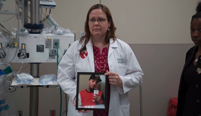 Charity Evans, M.D., a trauma surgeon and coordinator of the Dusk to Dawn (D2D) program at UNMC/Nebraska Medicine, holds a photo of Roberto Gonzalez, a 20-year-old Omaha man who was shot and killed in 2015. His death is being used as the centerpoint of the D2D program, as at-risk youth will hear his story when they come to UNMC/Nebraska Medicine for the D2D program.