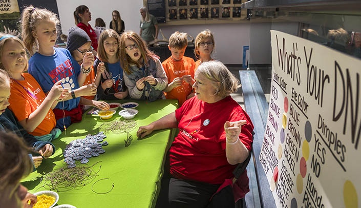 Elizabeth Kumru of the UNMC public relations department shows children how to make "DNA bracelets" at last year's Nebraska Science Festival.