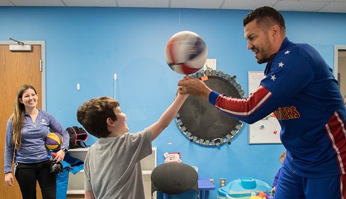 Orlando "El Gato" Melendez, right, shows off some Globetrotter trickery to a young fan at MMI.