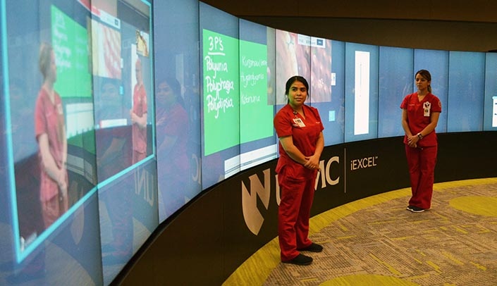 Jiosajandy Garcia-Reyna and Brigette Ixta-Perea, UNMC College of Nursing Omaha Division, demonstrate the iWall for a Board of Regents' visit last week with Richard Reinard and Mackenzie Bowker, nursing students in the West Nebraska Division in Scottsbluff.