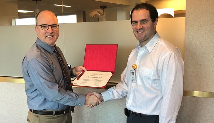Troy Plumb, M.D., fellowship program director, presents an award to Ryan Mullane, D.O., right, who was named a House Officer of the Year by the Graduate Medical Education Office.