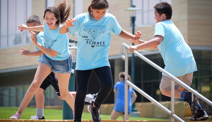 Talia Saunsoci, center, enjoys some free-time playing outside during a lunch break on June 5, the third day of the UNMC SEPA Health and Science Fun Camp.